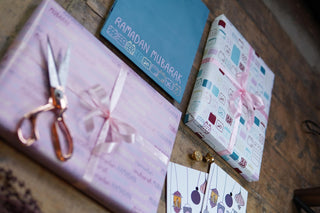 Gift-wrapped packages with ribbons and scissors on a wooden surface for ramadan